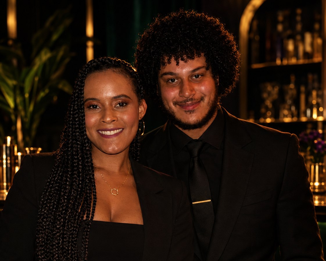 David and Cheeznah Baker, the founders of Clover & Cane, dressed in black at an elegant bar